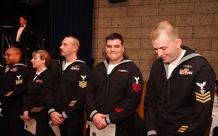 Petty Officer 1st Class Joseph Colon, second from right, reacts as he is named the 2003 Commander, Naval Forces Japan Sailor of the Year at an awards banquet on Friday night.