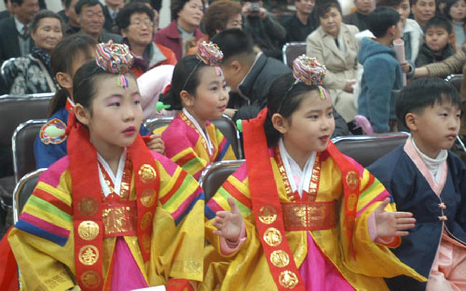 Students from the Tae Sung Dong elementary school, dressed in traditional Korean costumes, watch a graduation ceremony Friday. Tae Sung Dong is the only inhabited village in the Demilitarized Zone.