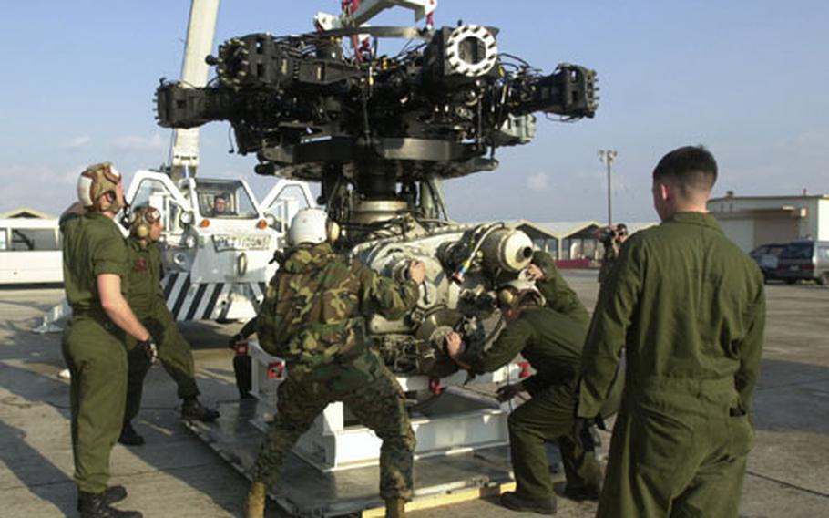 Marines from Marine Heavy Helicopter Squadron-465 position a gear box from a CH-53 onto a shipping pallet.