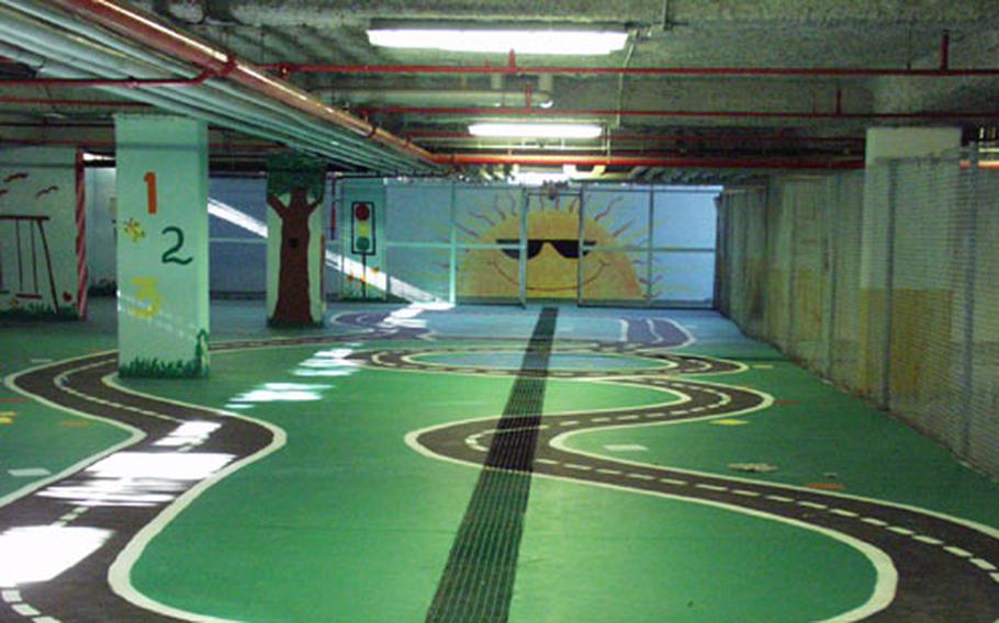 An underground parking lot at Aviano Air Base that's been closed to car traffic because of terrorism concerns is becoming a covered play area for kids. Dozens of volunteers at the base spent time painting colorful scenes and a track for tricycles.
