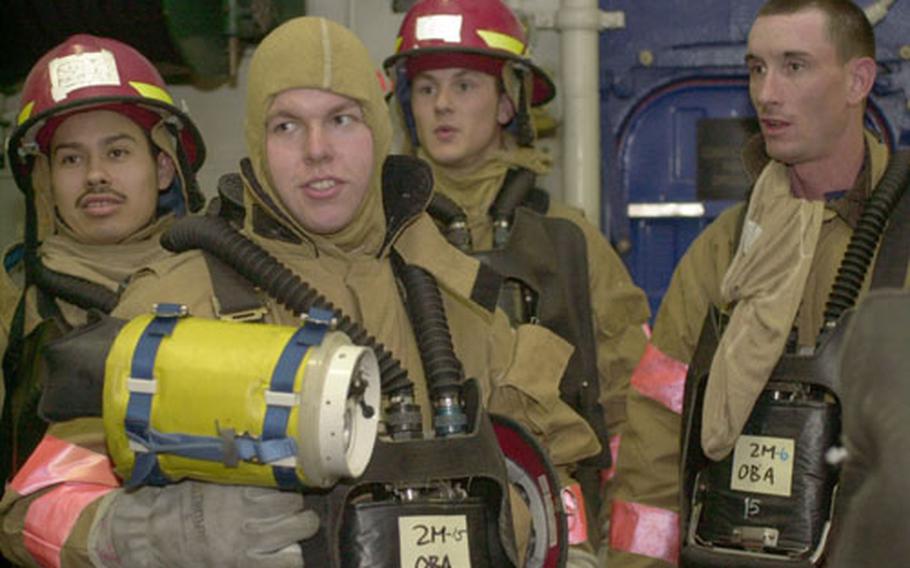 A group of Navy firefighters get ready for training aboard the USS Bataan on Thursday during "general quarters." The amphibious assault ship is on its way to the Persian Gulf to drop off Marines. The Navy wants its fleet and sailors to be ready to go on a moment's notice for "surge deployments."