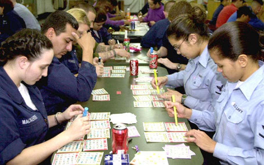 Sailors mark their bingo cards in the mess deck of the USS Bataan as it steams through the Arabian Sea on Saturday. Bingo is one of the most popular weekend activities aboard large U.S. Navy ships, where pots can exceed $2,500.