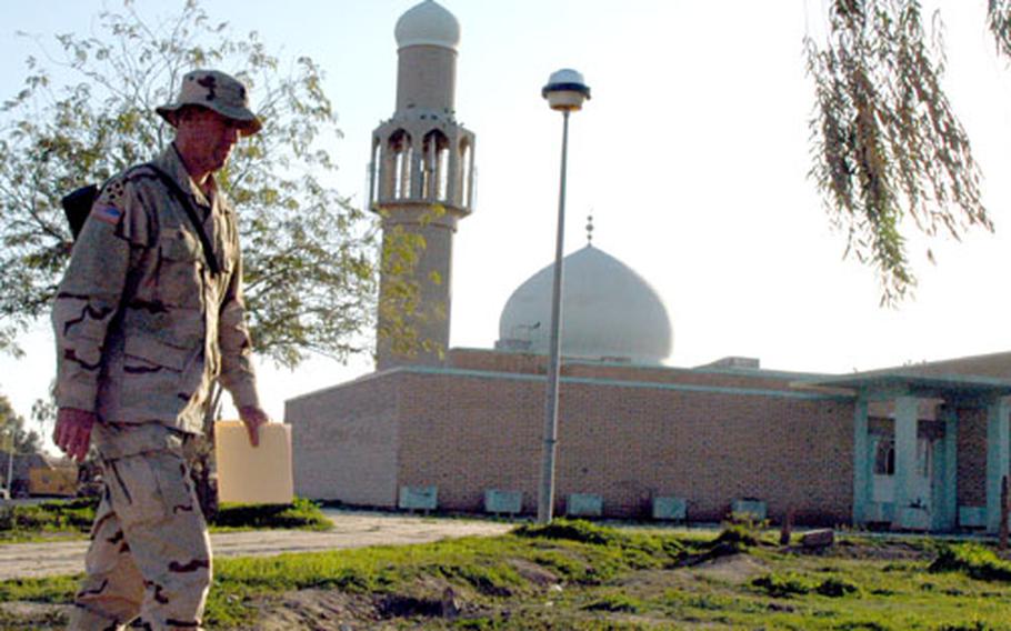 A soldier walks past a mosque at Logistics Support Area Anaconda in Iraq. U.S. military civil affairs officers plan to repair the mosque, which has been empty since the Iraqi air force pulled out of the area 11 months ago.