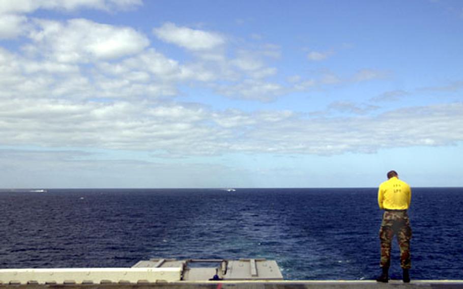 A sailor aboard the USS Bataan stands on the edge and takes a look at the Arabian Sea from the back of the ship. Because of security concerns, sailors are seeing a lot more water and a lot less ports as the Navy cuts down on the number of port visits.