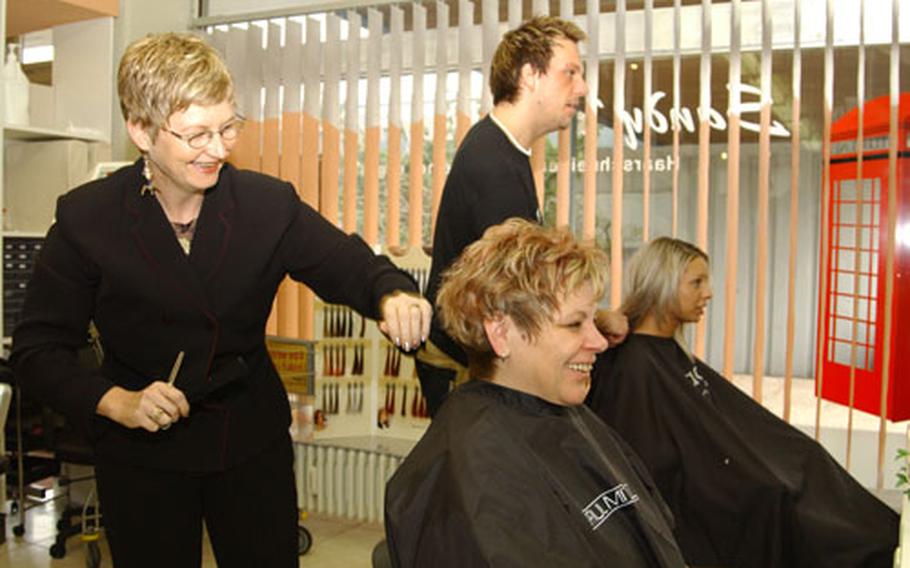 Sandy Wagner, left, and Sven Froehlich, right, work on two customers Friday at Sandy's Hairstyling Salon in Kaiserslautern. About 70 percent of the salon's clientele are Americans.