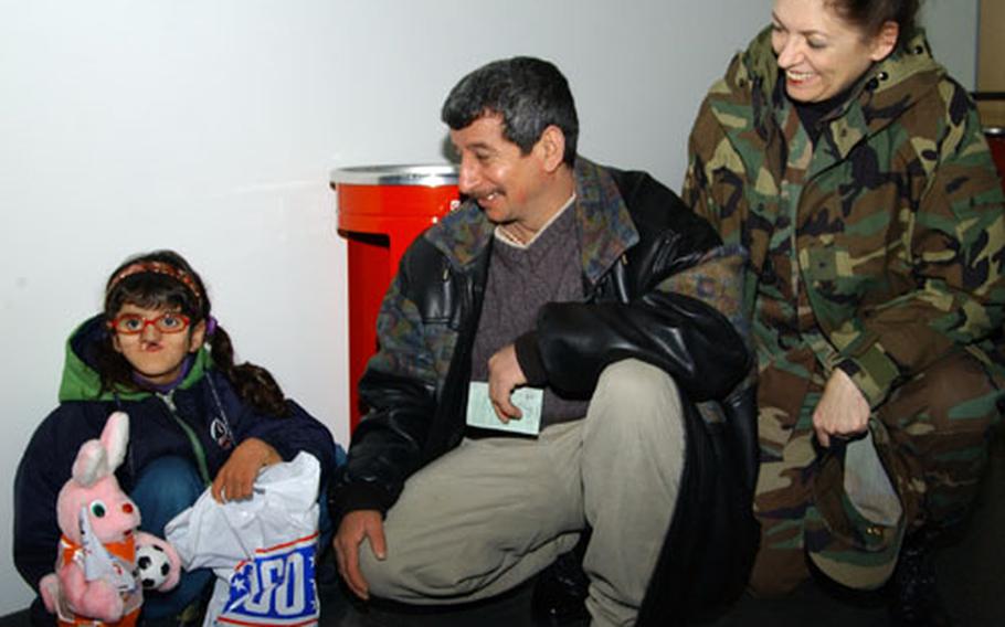 Brig. Gen. Rosanne Bailey, 435th Air Base Wing commander, meets Inas Ahmid Al-Mekelif, 7, and her father, Ahmid Al-Mekelif, Wednesday, at the Ramstein Air Base passenger terminal. Inas and another child were the last of 17 Iraqi children to return to Iraq Wednesday. The children had been treated at various Rhineland-Pfalz hospitals since October.