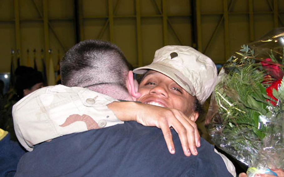 Spc. Roxsana Seale clutches her roses and gets a hug from her husband, David Seale, upon her return Wednesday to Wiesbaden Army Air Field. Seale, a member of the 19th Support Company, 3rd Corps Support Command, was serving at Balad Air Base, about 40 miles north of Baghdad, during Operation Iraqi Freedom.
