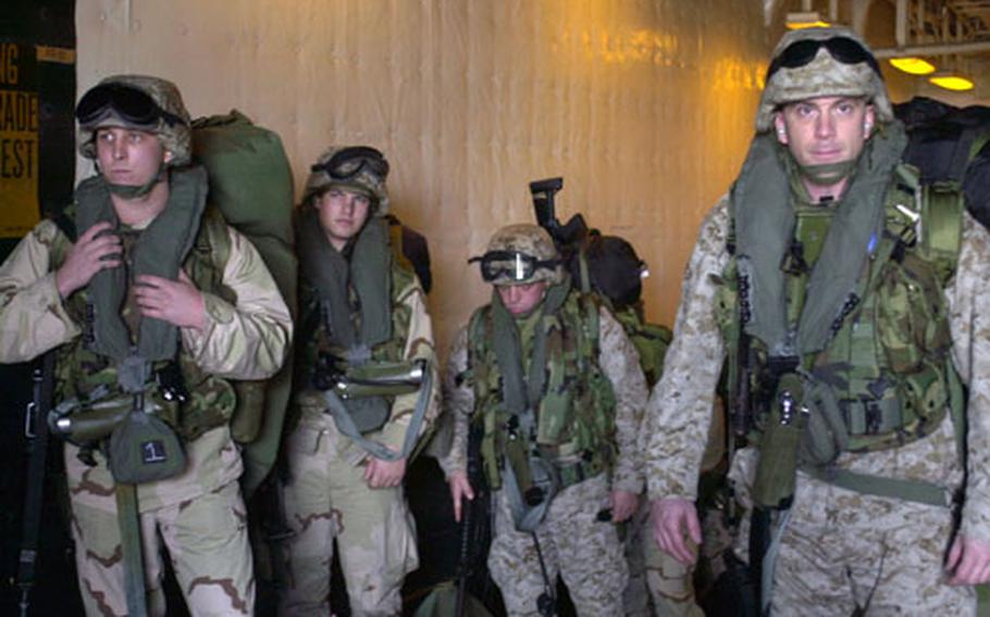 Marines from the II Marine Expeditionary Force prepare to get on a CH-46 helicopter from the USS Bataan on Friday. Two amphibious assault ships unloaded Marines and gear in Kuwait as part of a huge rotation of forces into Iraq.