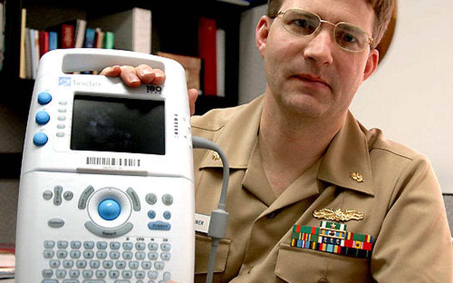 Lt. Cmdr. Tim Quiner shows just how portable are two new sonogram machines the Yokosuka base hospital bought recently for a total of $25,000. The machines are used primarily to confirm and date pregnancies.