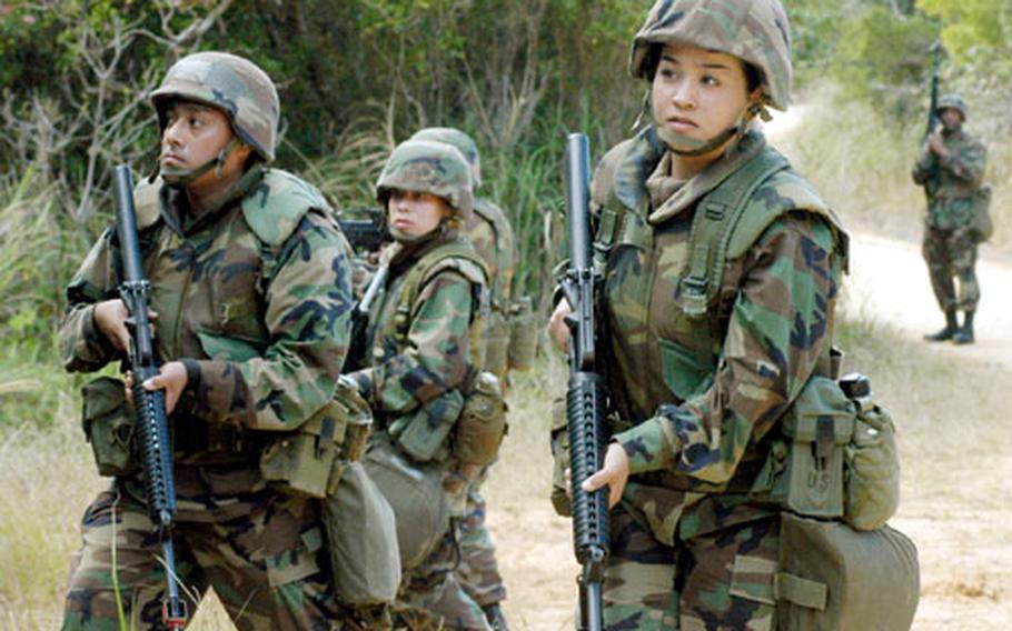 A squad of Seabees from Naval Mobile Construction Battalion Five ease along a winding, narrow road while attempting to secure a camp perimeter during a training Exercise Tuesday near Camp Hansen.