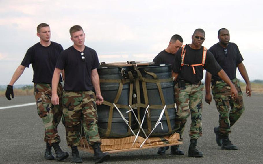 Airmen from the 18th Logistics Readiness Squadron/combat mobility element, Kadena Air Base, Japan, transport a container delivery system (CDS) after it landed at a drop zone during a low altitude airdrop training at Basa Air Base, Philippines, during exercise Balikatan 2004.