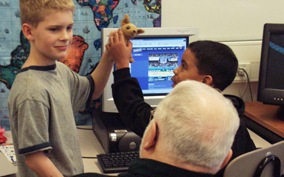 Joseph Douglass, a counselor at Aviano Elementary School in Italy, watches third-graders Cameron O'Steen, left, and Travis Matt during a recent lunch-hour visit to the Clubhouse. The school set up an extra classroom as a place for children of deployed servicemembers to send e-mail, play or talk about any problems they might be having during the deployment.