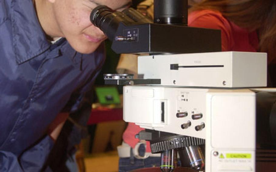 Seoul American senior Linus Lee gets a close up look at an asbestos sample Tuesday during presentations by the Corps of Army Engineers. Each year, the Corps shows teaches students about engineering careers as part of National Engineers Week.