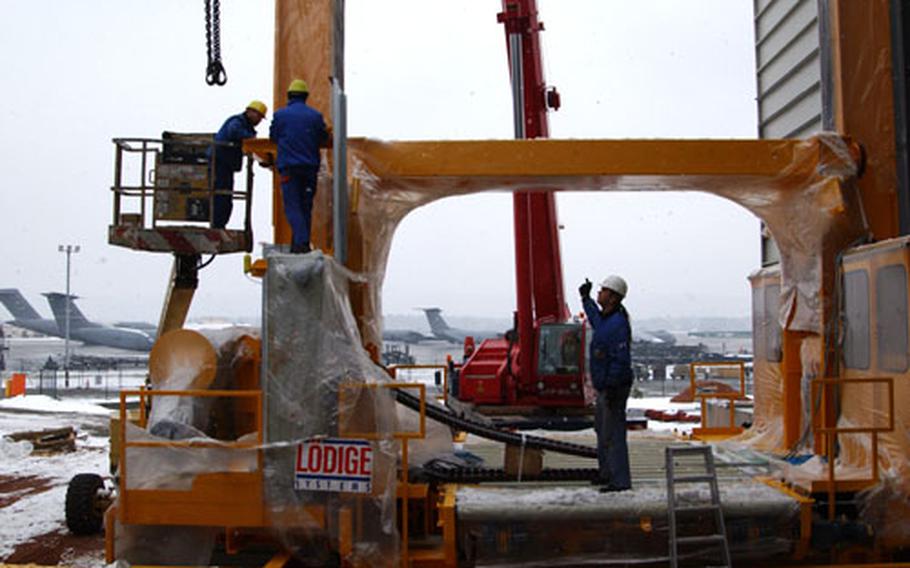 Workers assemble part of the Elevated Transfer Vehicle outside the Ramstein Air Base, Germany, air freight terminal. The ETV is part of the Mechanized Materiel Handling System, which will expedite the handling and storing of air cargo.