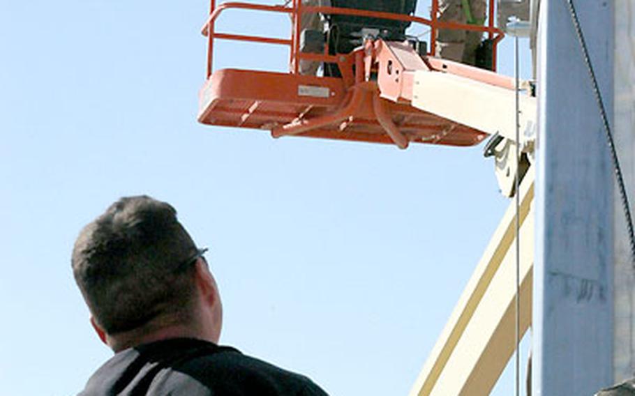 Master Sgt. Jim Lee watches Staff Sgt. Deseo Schultz and Staff Sgt. Brandon Lukacsko work on a tent-like structure that will soon serve as a movie theater at Tallil Air Base in southern Iraq. Much of the base’s flight mission has moved elsewhere, but airmen, soldiers and allied countries based at Tallil are kept busy with other missions.