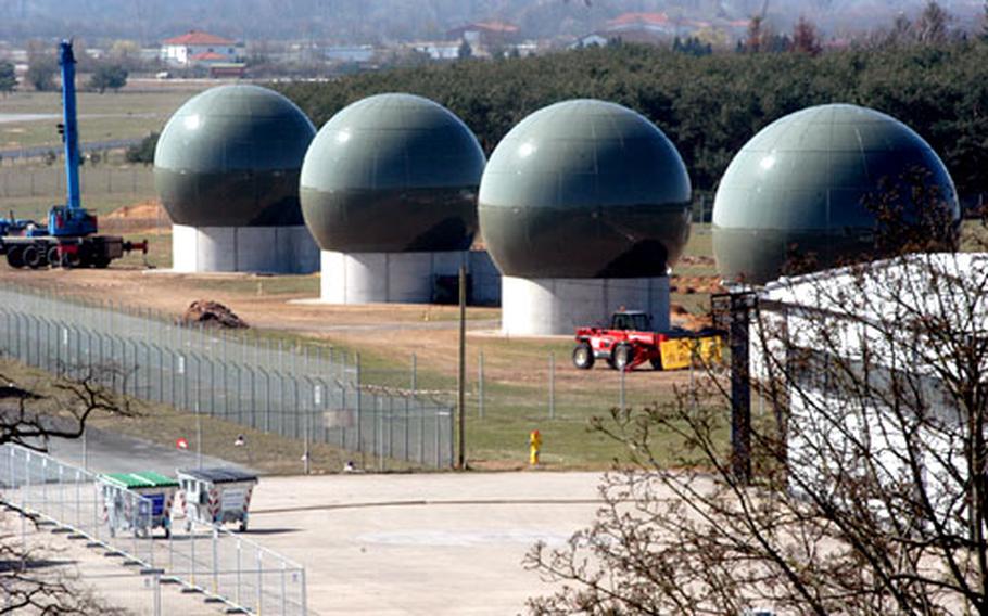 Four globes, part of a controversial U.S. Navy communications relay, sit at a rural airfield skirting Griesheim, Germany. Town residents fear the site may be radioactive or engaged in illegal espionage. The military has assured the town that its project is safe.