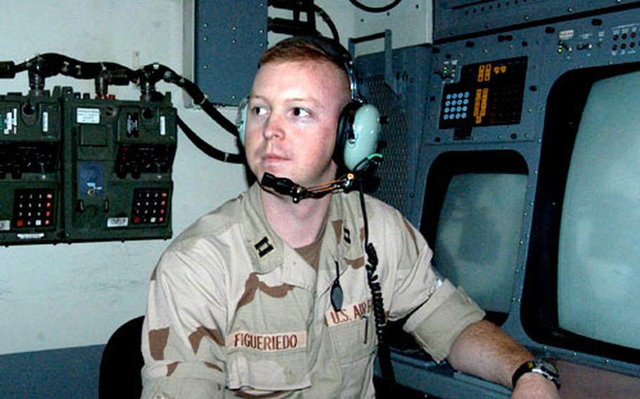 Capt. Erik Figueriedo, of the 322 Expeditionary Air Control Squadron, sits inside an operations module used for air traffic control at Balad Air Base.