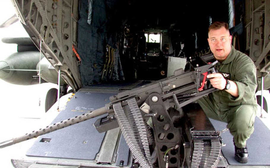 Gunnery Sgt. Daniel Hammer, deputy program manager for the Marine Corps’ Crew Served Weapons Defense Suppression Systems, demonstrates how the .50-caliber, ramp-mounted machine gun provides 180 degrees of coverage for the CH-53 Super Stallion helicopter. The Corps expedited the purchase of 24 of the Belgium-made GAU-21 guns to mount on Marine Corps helos now flying in Iraq.
