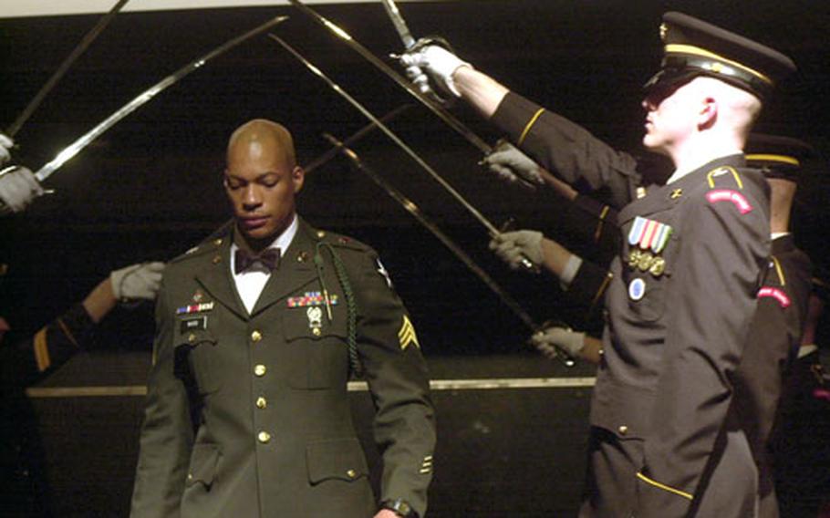 Sgt. Truman V. Ward of the 2nd Infantry Division walks under an honor guard's arch of swords at the USO's Six Star Salute Thursday night at the Hyatt Hotel. Eighty servicemembers were recognized for their efforts in South Korea.