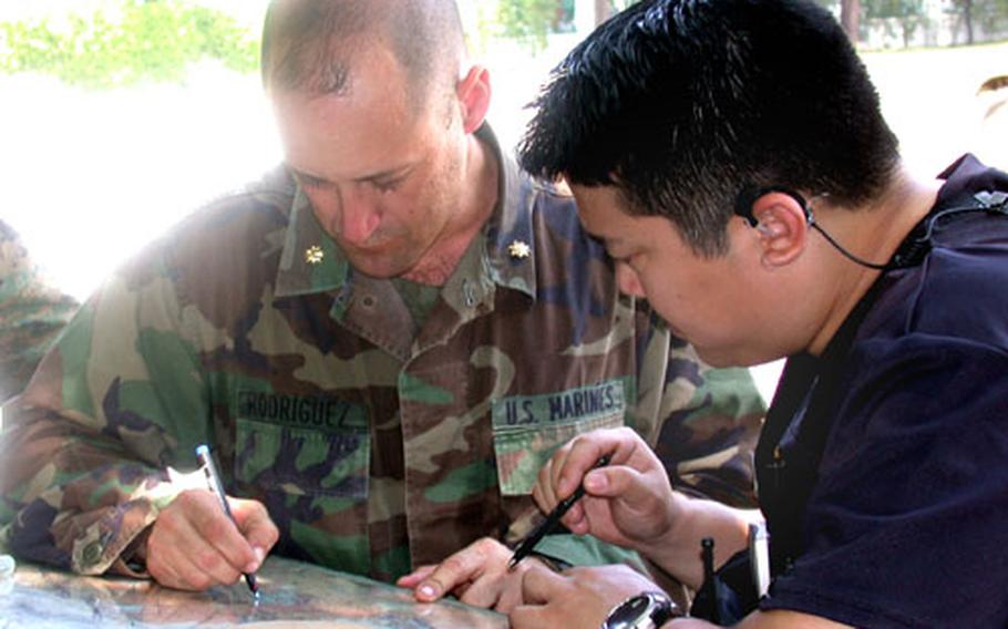 Maj. Justin Rodriguez, the executive officer of 3rd Battalion, 8th Marines, goes over the motorcade route to be taken by Secretary of State Colin Powell with Special Agent Scott Kim. Powell’s Monday visit to Port au Prince, Haiti’s capital, went off without incident.