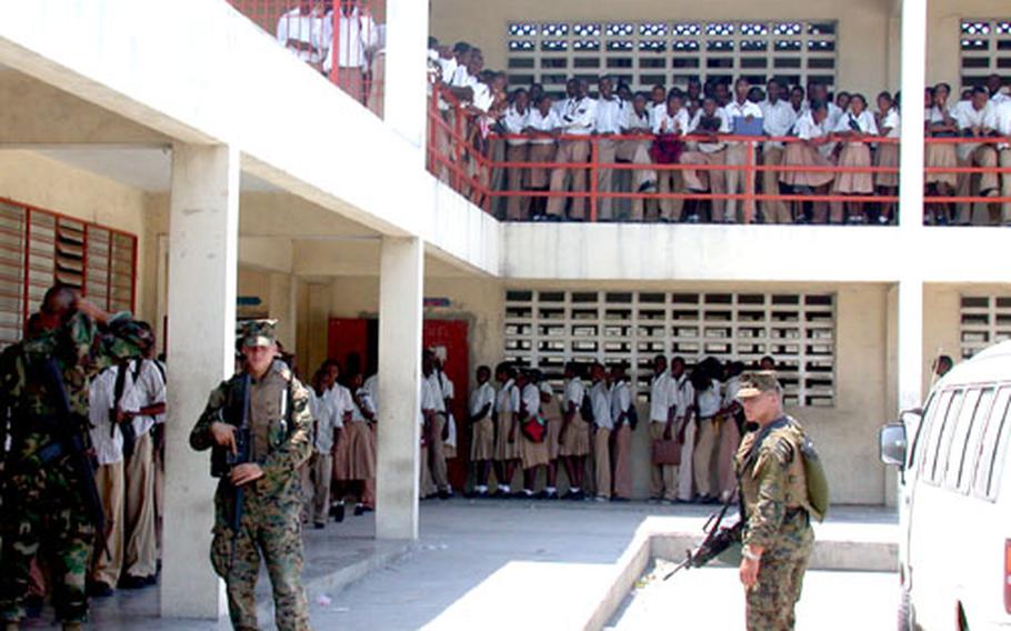 Hundreds of high school students of Lycee du Cite Soleil, in the impoverished neighborhood of Port au Prince, Haiti, line the balconies and file in to collect free school supplies handed out by U.S. soldiers and Marines.
