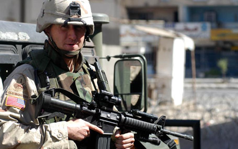 1st Lt. Jonny Fields, of the 1st Armored Division, stands watch in an alley off Al-Sadoon street in Baghdad on Friday morning.
