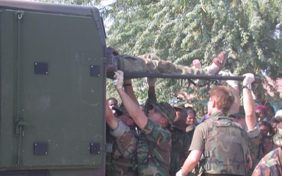Injured patients were loaded into many "double decker" military ambulances and taken to the fleet hospital on the compound housing the headquarters of the Combined Joint Task Force-Haiti. The truck flipped right outside of the headquarter's main gate.