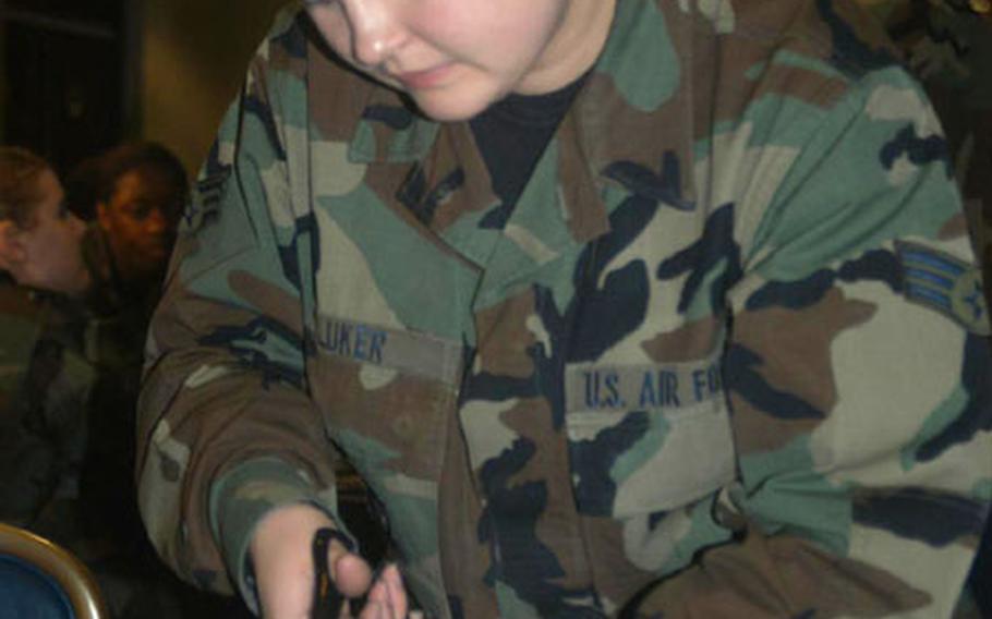 Senior Airman Sheila Luker of RAF Lakenheath, England, cuts old battle dress uniforms into panels, which will be sewn together to make blankets for the poor and homeless in England. Luker volunteered to help out with the program created by Senior Airman Dennis Fry of RAF Lakenheath.