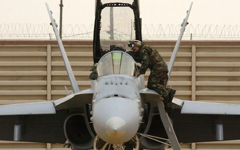 Marine Lance Cpl. Rinardo Rodriguez straps in the aircrew of an F-18D Hornet fighter before take off from Kunsan Air Base, South Korea, where a Marine fighter squadron from Iwakuni, Japan, is taking part in a two-week air-to-air combat exercise with an Air Force unit, the Kunsan-based 80th Fighter Squadron.