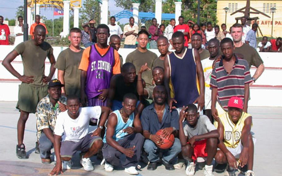 Following a game of U.S.-on-Haiti basketball Friday afternoon, the players gathered for a group photo. Each team played hard - and both claimed victory in the end. The game was coupled with missions to distribute fresh water and set up a health clinic.
