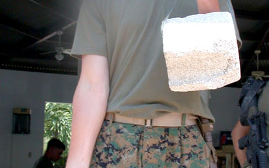 During his "down time" while deployed to Port-au-Prince, Haiti, Pfc. Mark Hamett, 18, occupies himself by lifting weights the rudimentary way. The dumbbells are made out of 3-pound cinder block pieces. Hamett is a radio operator with Communications Platoon of the 3rd Battalion, 8th Marines who have set up their headquarters firm base at a cigarette factory.