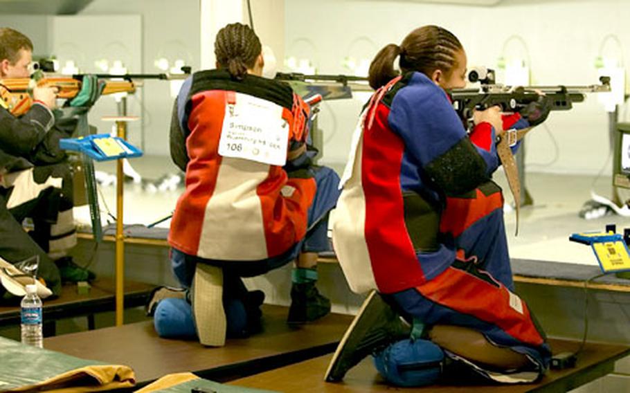 Katrina, center, and Kourtney Simpson, right, twin sisters and members of the Würzburg, Germany, rifle team, fire their weapons during day one of the National All-Service JROTC Rifle Championships.
