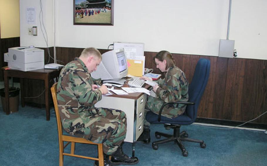 Air Force 2nd Lt. Nikita Belikov of the 607th Combat Communications Squadron gets help with his federal taxes Wednesday from Senior Airman Michelle Vargo, a volunteer at the tax center on Osan Air Base, South Korea. Its scheduled close was Thursday night.