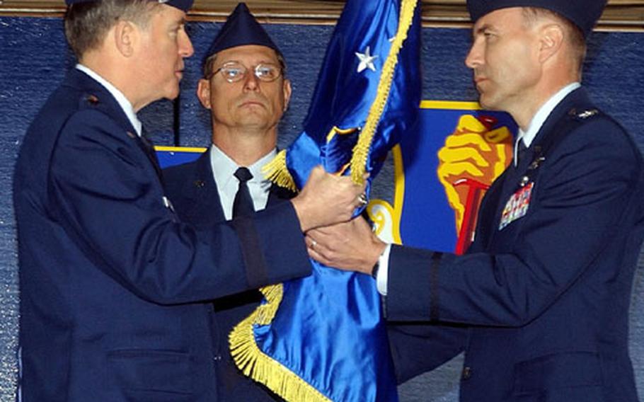 Lt. Gen. Thomas Waskow, U.S. Forces Japan and 5th Air Force commander, passes the guidon of the 35th Fighter Wing, Misawa Air Base, Japan, to Col. William J. Rew, right, during the 35th Fighter Wing and Misawa installation change of command ceremony Thursday. Colonel Rew assumed command from Brig. Gen. Dana T. Atkins, who moves on to become vice commander, Seventh Air Force and United States Air Forces Korea, and chief of staff, Air Component Command, Osan Air Base, Republic of Korea.