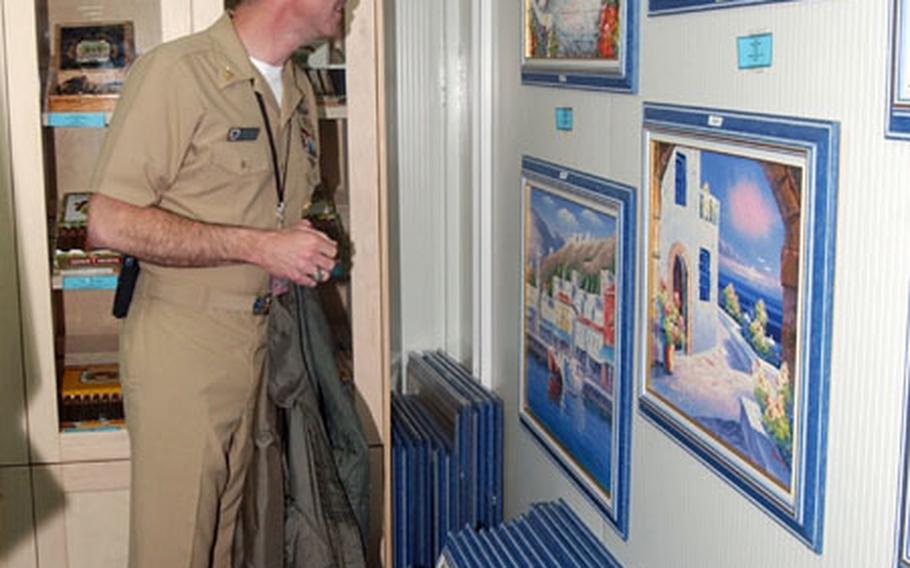 Master Chief Petty Officer Jerry Daniels of Naval Support Activity Souda Bay, Crete, looks at paintings at a new gift shop on the base's Marathi pier facility.