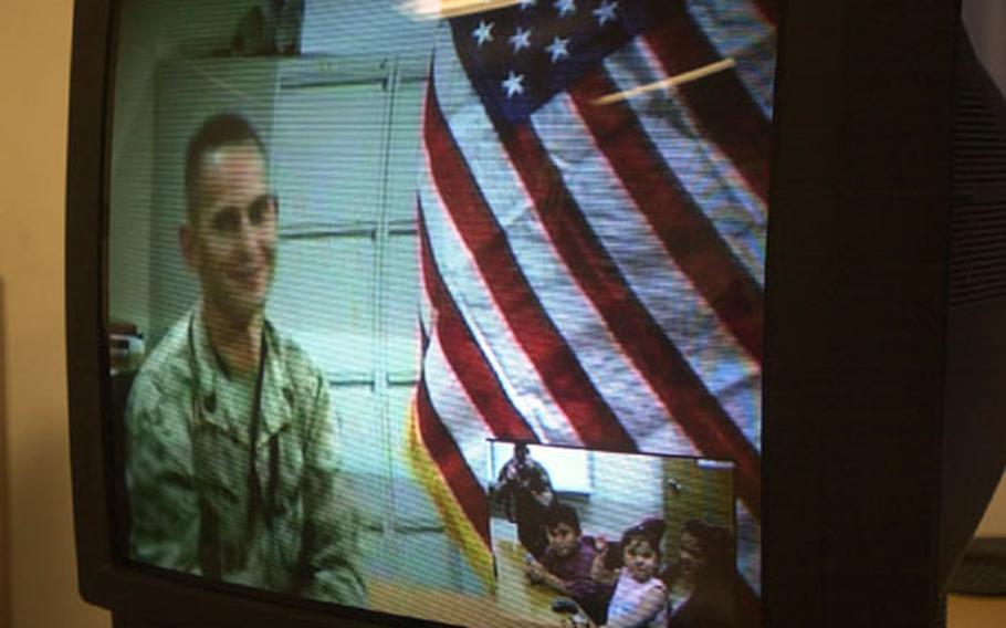 Gunnery Sgt. Larry D. Liechty, left, gets a chance to chat with wife Sheila and children L.J. and Victoria before his reenlistment via video teleconference Friday. Liechty is deployed to Baghdad with Combined Joint Task Force-7.