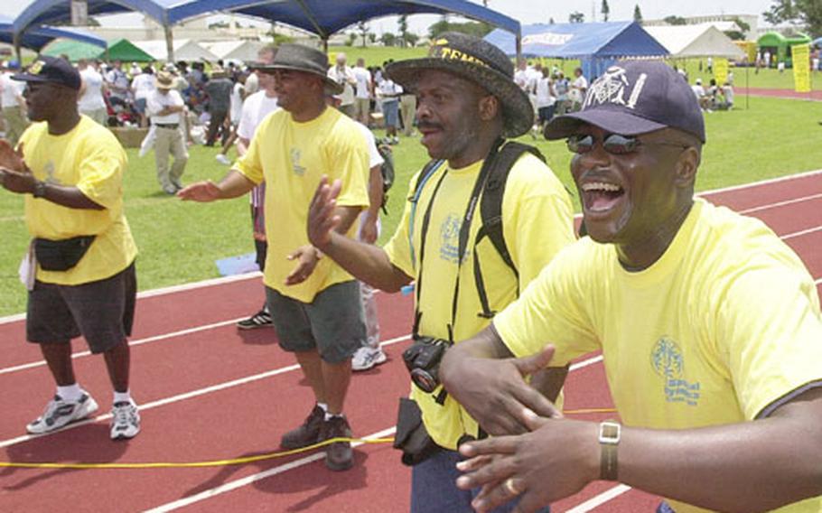 Volunteer encouragers, from right to left, Marine Staff Sgt. Kelvin Roberts, Earl Gittens, Gunnery Sgt. Darryl Dyson and Gunnery Sgt Terrell Lasker cheer on runners in a 100-meter dash at last year's Special Olympics. Organizors are still looking for volunteers for this year's games.