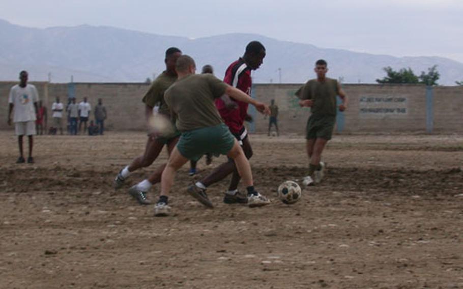 U.S. Marines from India Company, 3rd Battalion, 8th Marines battle it out on soccer field Saturday in the slums of the Cite Soleil, Port-au-Prince, Haiti. Building trust between the gangs and the Marine Corps aids the Marines in gaining the respect of the general population in the impoverished neighborhood. The game was supposed to have included Haitian National Police, but they did not show up.