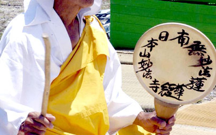 Hiroo Naganuma, a Buddhist monk, beats a drum for peace at Henoko's fishng port Tuesday. Nahanuma was one of about 50 protesters camped out at the port in opposition to plans to build a new U.S. Marine air station.