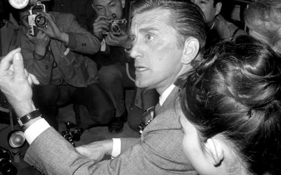 Kirk Douglas and his wife, Anne, arrive in Tokyo in March, 1964. The actor was visiting Japan as part of a State Department program, as well as to promote his latest film, "Seven Days in May."