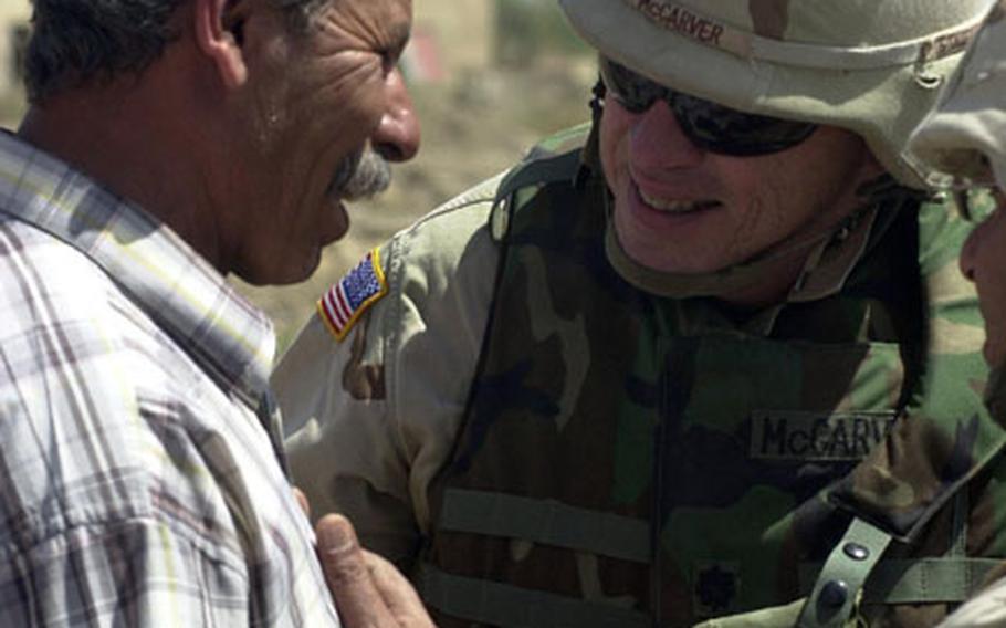 Lt. Col. Ray McCarver Jr., 15th Forward Support Battalion commander, talks with Adnan, a 30-year veteran of Saddam's Republican Guard. McCarver is gambling that with Adnan and other community leaders' support, he can keep locals from selling out to anti-American elements.