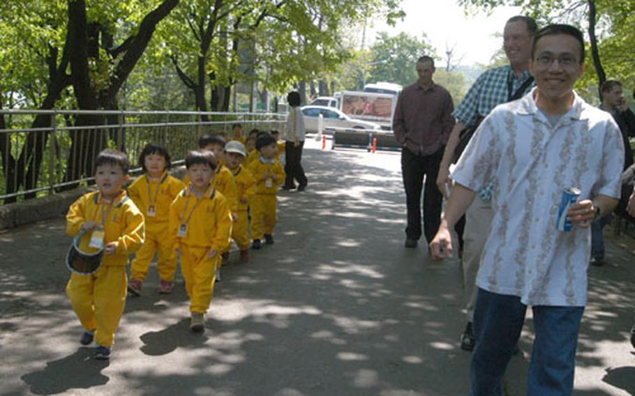 U.S. servicemembers (right) walk toward Seoul Tower alongside South Korean pre-schoolers (left) on Wednesday.
