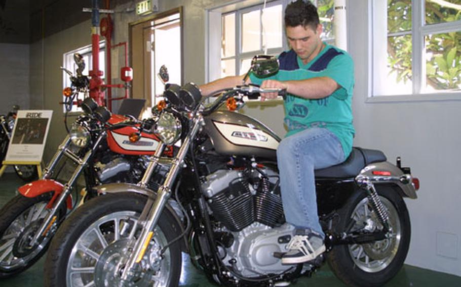 Navy Airman Matthew Guyette, of Helicopter Antisubmarine Squadron 14, checks out a motorcycle at the newly opened Harley Davidson showroom at Naval Air Facility, Atsugi. This and many other bikes are on display. The showroom's grand opening is scheduled for Saturday, with a ribbon-cutting ceremony at 10 a.m.