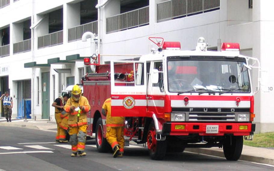 U.S. Naval Forces Japan, Regional Fire Department personnel at Sasebo Naval Base retrieve and load their gear after a simulated bomb explosion on a bus at the main base facility Friday morning.