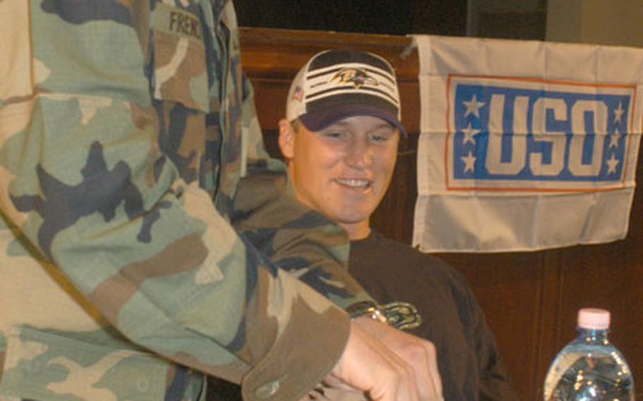 Todd Heap, tight end for the Baltimore Ravens, gets help from a 1st AD soldier on how to properly eat a Meals, Ready to Eat. Heap said his meal wasn't too bad, but he still traded his Skittles candy for some M&Ms.