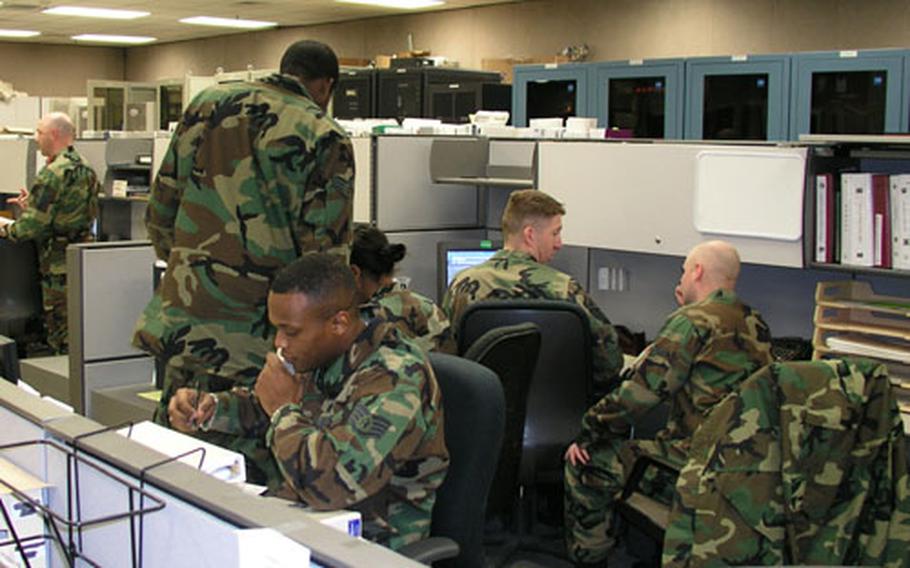 At Osan Air Base in South Korea, airmen of the 51st Communications Squadron staff the base's network control center, keeping tabs on a wide range of computer-related matters, including watching for viruses. At center of photo, on phone, is Staff Sgt. Jabbar Williams, checking the status of a computer security matter.