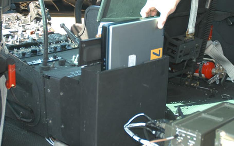 Chief Warrant Officer 4 Douglas Hettler, aviation maintenance officer, shows how laptops are stored in a UH-1 Huey helicopter at Hohenfels. Hettler is with the Combat Maneuver Training Center Aviation Flight Detachment, which was recently recognized for the best aviation maintenance for a small unit in the Army. The laptop computers automated most of the paperwork crew chiefs and pilots were required to fill out for each flight, Hettler said.