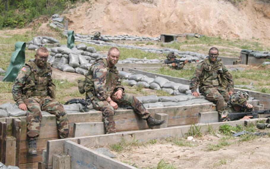 Soldiers from 1st Platoon, B Company, 2-9 Infantry Regiment "killed" in an attack by the Blue Force at Mohawk Range wait while their surviving comrades guard the trench they "died" to take during the exercise.