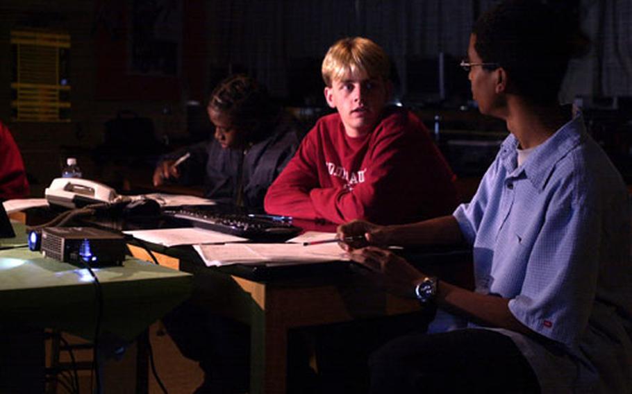 Thaddeus Reap, left, records data while Nicholas Ziegler, center, talks with Phillip Clark during the students' time controlling the Goldstone Apple Valley Radio Telescope in Apple Valley, Calif. The three students are juniors at Kubasaki High School on Okinawa and were the first students to take part in the GAVRT program at the high school.