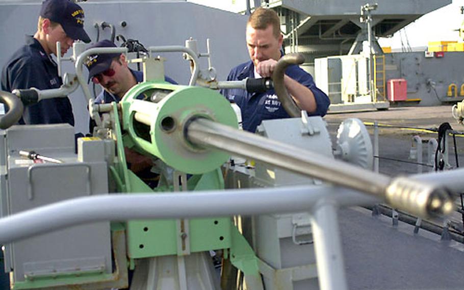 Navy Petty Officer 2nd Class Chad Glover, Chief Petty Officer Greg Tillery and Petty Officer 1st Class Christopher Cooke prepare a Mark 38 25mm machine gun aboard the USS Typhoon at Naval Station Rota, Spain. Patrol boats USS Typhoon and USS Sirocco stopped in Rota on their way to the Persian Gulf.